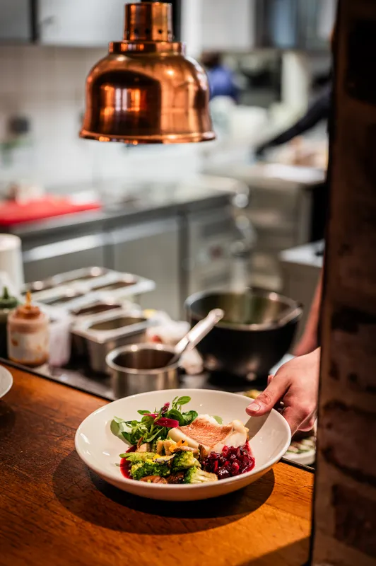 Une assiette dressée en cuisine, sous la lampe chauffante